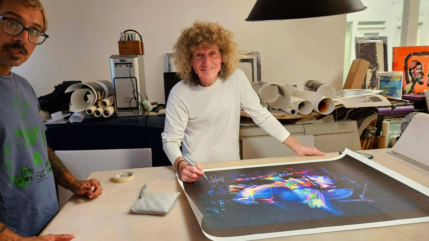 Tommy Aldridge hand-signing an Off The Hook canvas